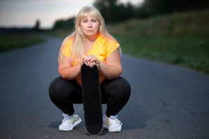 A woman in plus-sized skateboarding clothes