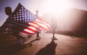 Skateboarder carrying an American flag