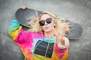 A woman with skateboard wears a comfortable clothing.