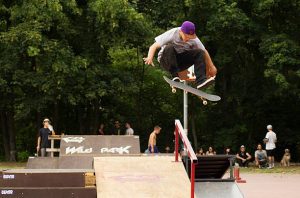 A man is doing a longboarding stunts in the park.