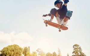 A skateboarder jumping high with his skateboard.