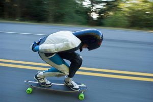 A person skating on the road. 