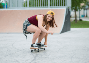 An adult woman trying her very best to skate. 