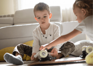 2 little boys cleaning their skateboard.