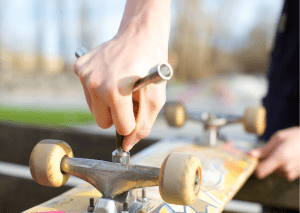 man adjusting a skateboard 