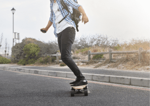 A man rides his newly charged electric skateboard while going to work. 