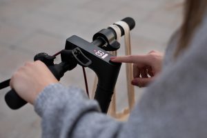 A woman pressing the best app feature in their electric scooter