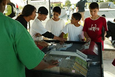 These boys are enjoying the finger scooters that they are holding. Each finger scooter has a personalized deck that they have created.