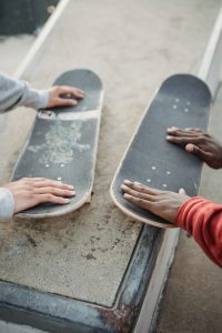 Two persons fixing the decks of the skateboards