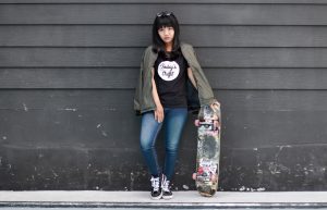 Skateboarding gear includes good quality items such as helmets, pads, and shoes, check this girl flaunting her items while holding the board