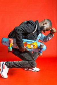 A man is holding a colorful skateboard 
