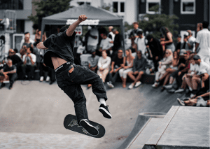 A man doing jump tricks at a skate park