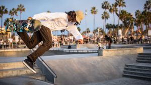 Boy Embraces Popular Culture with Joyful Skateboarding in the Park