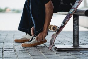 Man wearing appropriate shoes before riding his board