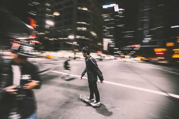 Skateboarder riding his board at night.