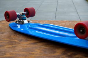 Skateboard with red skateboard wheels. 
