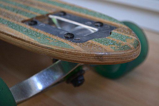 A combination of green and brown scooter grip tape is applied to a scooter's deck or platform to enhance grip and prevent slipping from the scooter.
