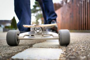 A man ready to ride his electric skateboard. 