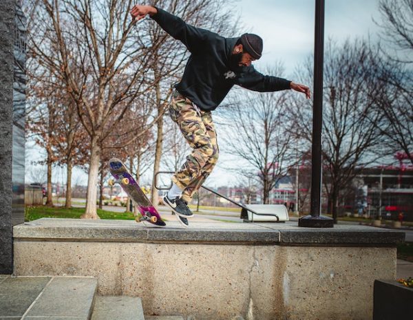 Man with hoodie performing skateboarding tricks