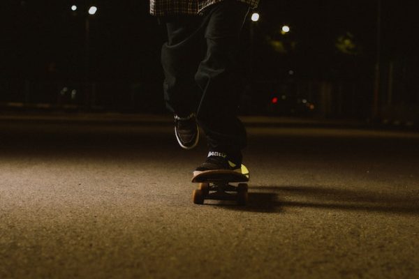 A skateboarder is skateboarding safely at night. Nighttime skateboarding