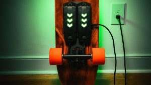 Electric skateboard with wheels charging getting ready for an electrifying skateboarding experience. These high-performance skate wheels of electric skateboard provide an efficient and smooth skateboarding ride.