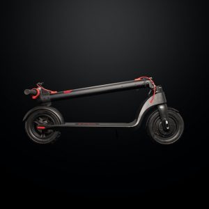 A folded red and black scooter against a black background, prepared for hanging on a Scooter Wall Mount. Scooter wall mounts are a great solution for scooter storage. 
