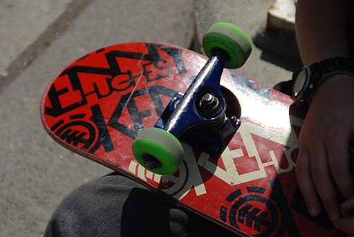 a red skateboard with green wheels for adults