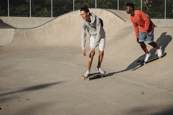 skateboard - Two men are doing tricks on a skateboard ramp.