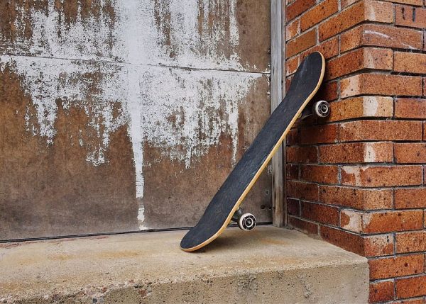  Skateboard - A black skateboard is placed on the side with its maintained position.