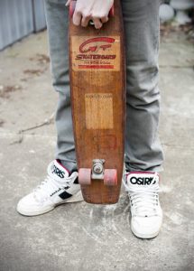 A man is holding an old board with retro and old style with designs.