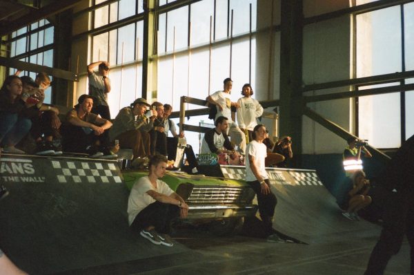 Teenagers participating in a street skateboarding class in an indoor setting.
