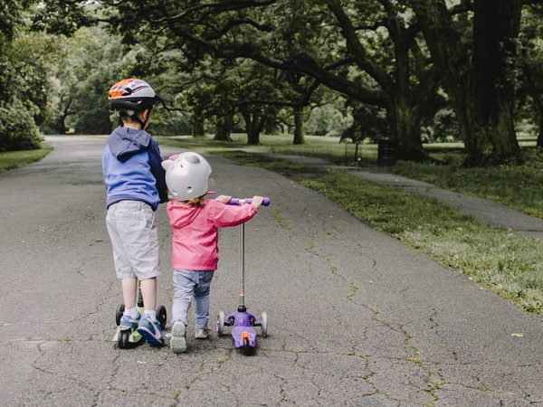 Kids riding on their scooters.