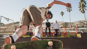 Perfect trick performed by a man on the skateboard sidewalk.