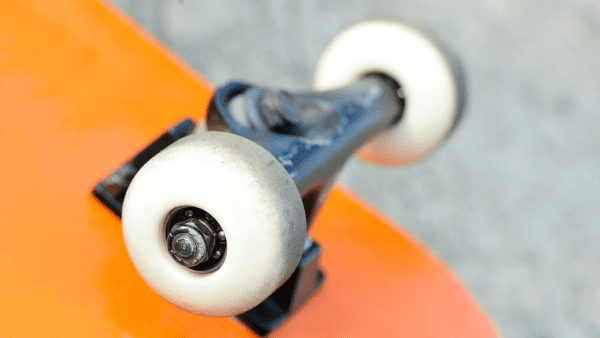 Skateboard bushings and the two wheels. The board's color is orange.