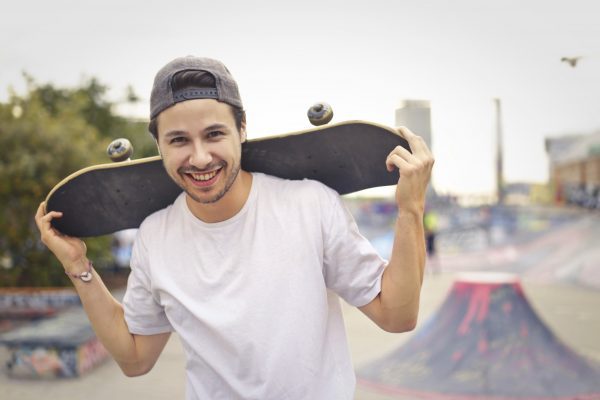 A man carrying a skateboard.