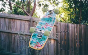 DIY skateboard accessories: A colorful skateboard suspended in mid-air accented with green skate wheels.