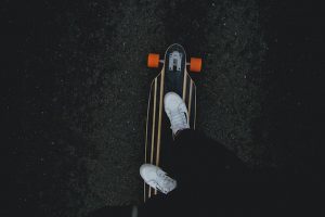 A skater with new skateboard wearing his skateboard shoes. Skateboard types