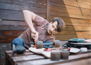 Skateboards: Person tightening the trucks of a skateboard.