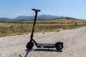 A black two-wheeled vehicle with best braking system is parked in the countryside. 