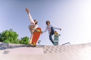 two skateboard riders in action doing tricks on their individual skateboard