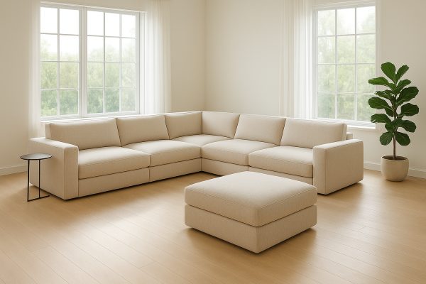 A modular sectional sofa in a U-shape with a separated ottoman, in a bright living room with light wood flooring.