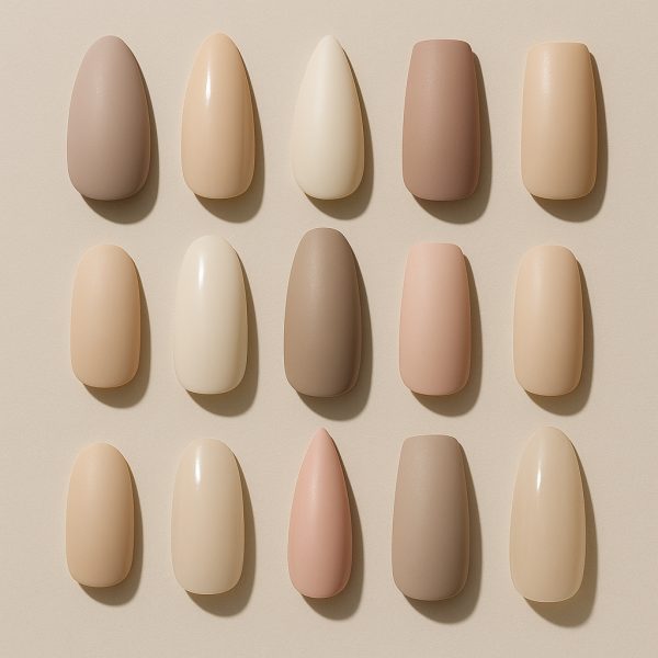 A crisp flat lay of press on nails in several shapes and lengths, set on a neutral matte surface.