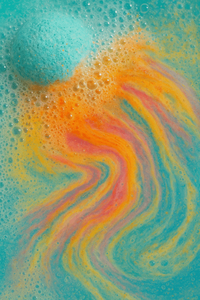 Macro of fizzing bath bomb with vibrant bubbles and swirling color.