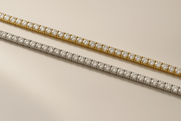 Tennis bracelets in yellow gold, white gold, and platinum arranged on an ivory slab for visual comparison.