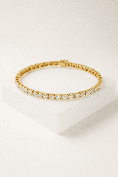 Gold tennis bracelet with round-cut diamonds arced on a floating matte-white stand.