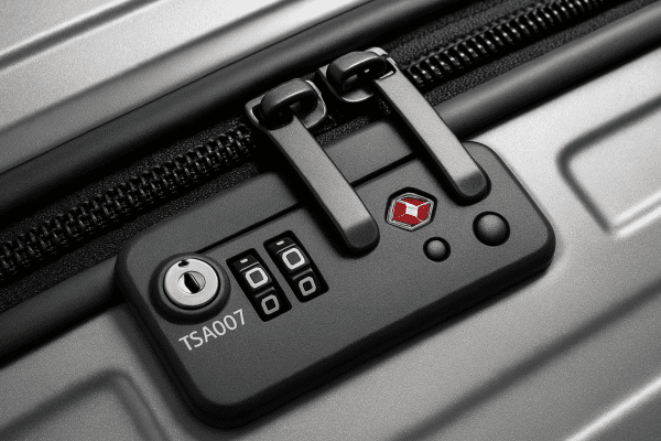 Macro detail of a suitcase TSA lock showing robust security and clear symbols.